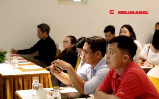 Anh Vũ Huy Song (áo đỏ) cùng các khách mời đang theo dõi những chia sẻ về cách lắp đặt MC4-Evo 2 trong dự án năng lượng mặt trời.