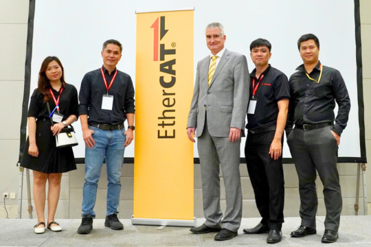 Ông Martin Rostan, Executive Director của EtherCAT Technology Group (áo vest xám) chụp hình cùng ông Prapan Angsuthasawit, Tổng giám đốc công ty HELUKABEL Việt Nam (đứng thứ 2, áo sơ mi đen, từ trái qua phải) và các kỹ sư của công ty HELUKABEL Việt Nam.
